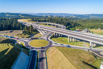 New highway in Poland on national road no 7, E77, called Zakopianka.  Overpass junction with a traffic circle, slip roads and viaducts near Skomielna Biala. Aerial view. Far view of Tatra Mountains - 372523159