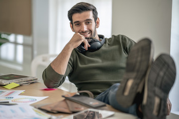Businessman designer in casual costume sit comfortably foot on table in office