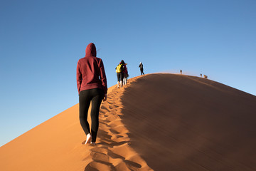 Grupo de personas subiendo la duna 45 en el desierto de Sossusvlei, Namibia.