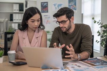 Business team during meeting conference are working documents about the marketing plan and finance sales report of the company with laptop computer