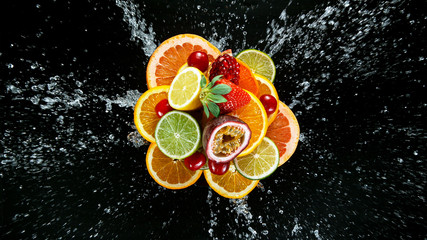 Fototapeta na wymiar Freeze Motion Shot of Fresh Fruits with Splashing Water Isolated on Black Background.
