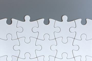 Obraz premium White jigsaw puzzle pieces on gray background