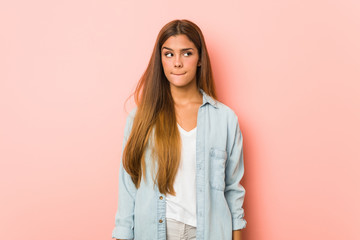 Obraz premium Young slim woman confused, feels doubtful and unsure.