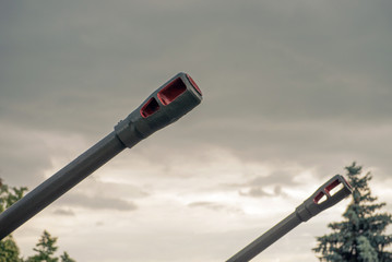barrel of an artillery gun on the background of dramatic cloudy sky close-up