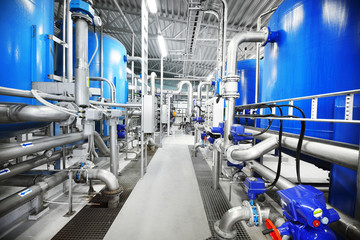 Large blue tanks in a industrial city water treatment boiler room. Wide angle perspective. Special equipment, technology, drinking water supply, chemical modifications, environmental conservation - 372527563
