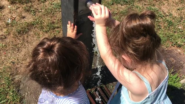 Hermanas refrescándose en una fuente de agua