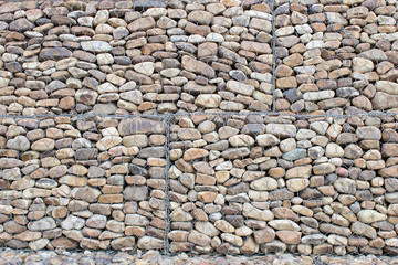 Stonewall with a protective mesh for safety. Texture background.
