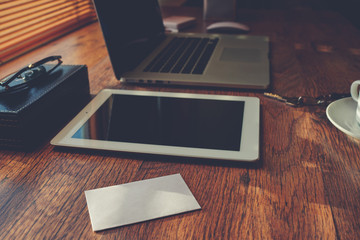Mock up with business person luxury accessories and work tools, cup of american coffee, sunglasses, envelope, digital tablet and laptop computer, hipster office workplace desktop, filter an flare