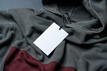 Blank White Rectangular Clothing Tag, Label Mockup Template on Gray And Tile Colored Stylish Sportswear. Price Tag Label With Copy Space, Empty Space