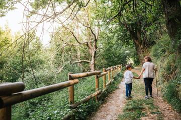 mother walks her 6-year-old son through the woods