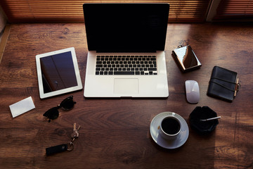 Mock up of successful person with luxury accessories and work tools, cup of american coffee, mouse,envelope,digital tablet and laptop computer with blank copy space for text message, freelance desktop