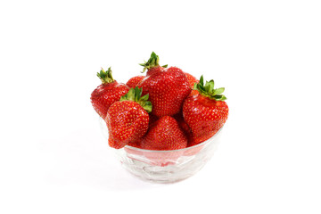 Red juicy strawberries lie in a transparent plate on an isolated white background in the center. Sweetest and most beautiful strawberries in red berries, isolated on white background