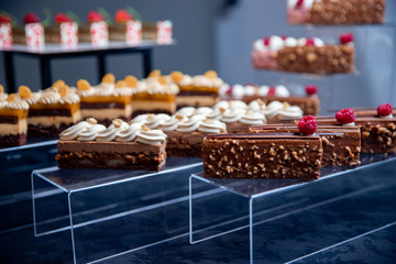 Sweet dessert table for catering and wedding with chocolate brownies and muscakes on dark background