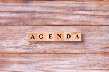 AGENDA word written on wood block. List of matters agenda business concept