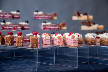 Sweet dessert table for catering and wedding with chocolate brownies and muscakes on dark background
