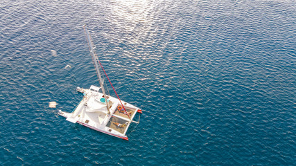 Aerial top view to catamaran sailing in open sea on a blue water at windy day. Drone view