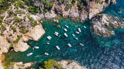 Aerial view of beautiful coastline in Mediterranean coast of Spain, Costa Brava. Panorama of Rocks on the coast in beautiful summer day. Beautiful beach with turquoise sea, boats, holiday destination 