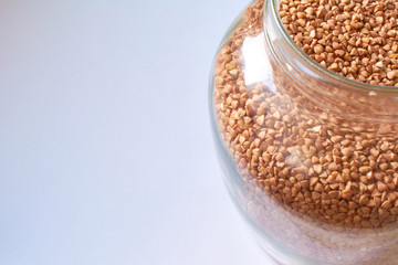Buckwheat in bank onwhite background. Healthy food. Fresh cereals.