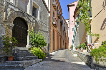 Fototapeta na wymiar A narrow street among the old houses of Tortora, a rural village in the Calabria region, Italy.