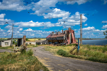 Obraz premium An old abandoned grain Elevator. Forgotten villages. Destroyed agriculture.
