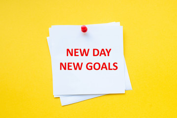 New day new goals. Motivational slogan on white sticker with yellow background