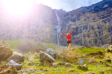 happy woman enjoying Pyrenee mountain and waterfall