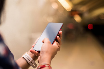 Hands woman using smartphone on the underground. Mockup mobile phone girl touching screen.