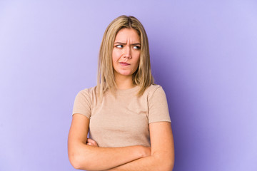 Young blonde caucasian woman isolated frowning face in displeasure, keeps arms folded.