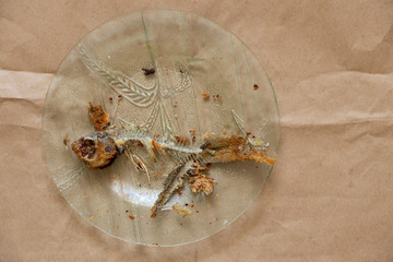 fried fish skeleton in glass plate on isolated background close up