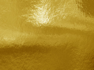 Gold foil background with highlights and uneven texture