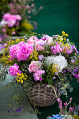 Large floral arrangement in a wicker basket of peonies and wildflowers