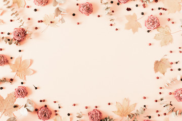 Autumn creative composition. eucalyptus, berries, leaves, roses, flowers on pastel pink background....