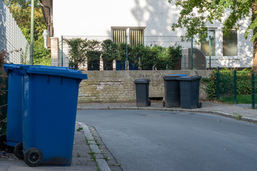urban street with rubbish bins out for collection 