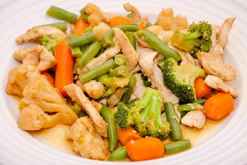 Stir fry chicken & vegetables. Stirfry chicken vegetables meal, food for dinner. Vegetables - green beans, cauliflower, broccoli, carrot, chicken meat stir fry on white plate. Healthy stir fry lunch