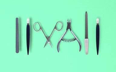 Set of isolated nail scissors, nail clippers and nail file on green background 