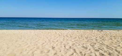 Fototapeta na wymiar ideal seascape - yellow sand, blue sea, blue sky.