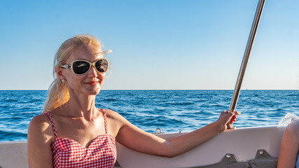 Joyful resting on a yacht, an adult with a beautiful smile on the sea horizon, enjoy the concept of monochrome glasses, beautiful horizon