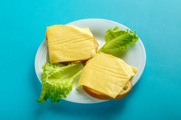 Sandwiches with cheese and cherry on a plate on a blue background. Copy place.