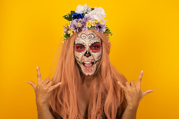 Born to rock this world. Joyful woman wearing halloween make up  screaming out loud and showing...