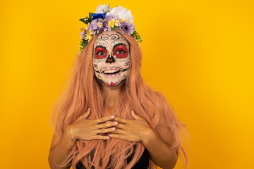 Happy business woman standing and smiling isolated on gray studio background has hands on chest near heart. Young emotional woman. Human emotions, facial expression concept. Front view.