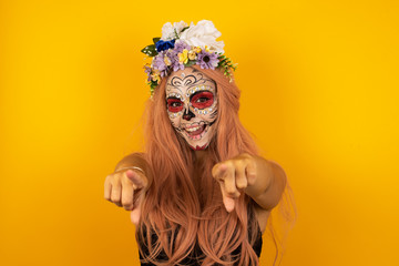 Close-up portrait of surprised pretty young woman in casual clothes pointing with two fingers to the camera saying: I choose you!, looking up with open mouth, isolated over background