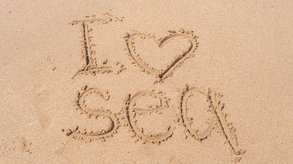 Inscription on the sand, I love the sea, written with my finger on the sea shore, the beach in the summer weather