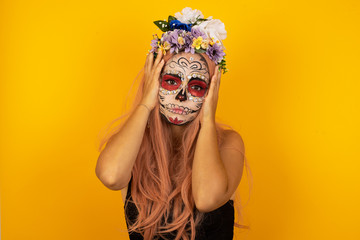 Portrait of beautiful young woman holding head in hands with unhappy expression watching sad movie...
