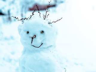 turquoise Snowman with dry twig hair is smiling. Winter vacation. Christmas entertainment.