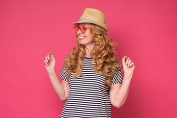 Obraz na płótnie Canvas Beautiful mature woman wear sunglasses and hat smiling. Enjoy summer holiday isolated on pink background.