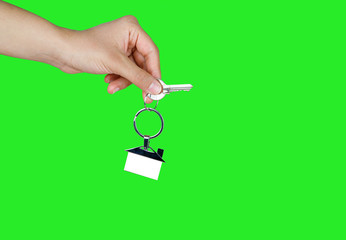 House key in woman hand. green background