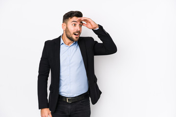 Young caucasian business man against a white background isolated looking far away keeping hand on forehead.
