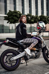 Fototapeta na wymiar Very beautiful girl on a stylish purple motorcycle