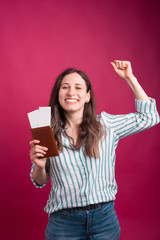 Naklejka premium Young woman is celebrating the journey she won over pink background.