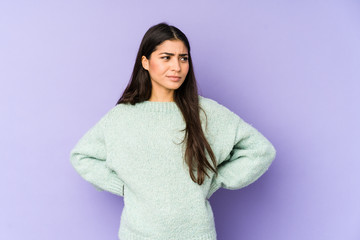 Fototapeta premium Young indian woman isolated on purple background confused, feels doubtful and unsure.